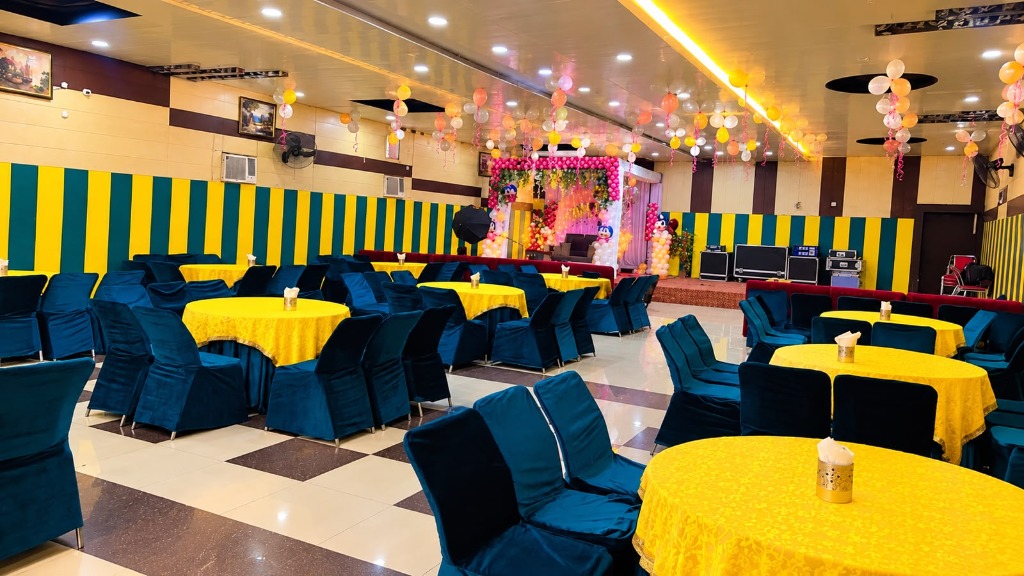 Festive banquet hall with hanging balloons, golden table settings, and family party setup